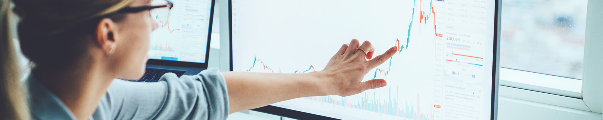 woman pointing a peak on a financial chart
